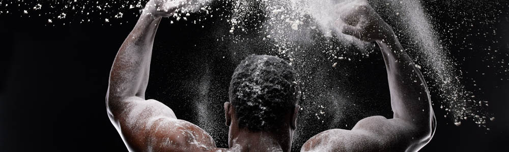Strong man clapping his hands together to release chalk into the air